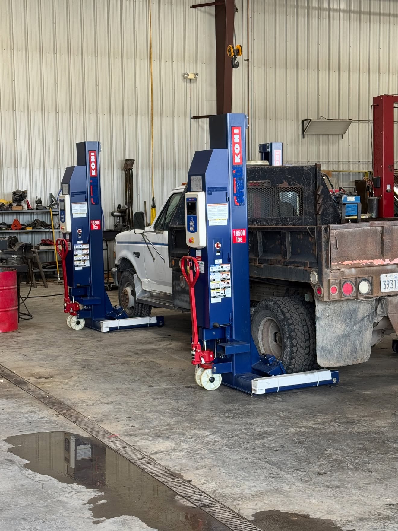 Mobile column lifts positioned around a fleet work truck