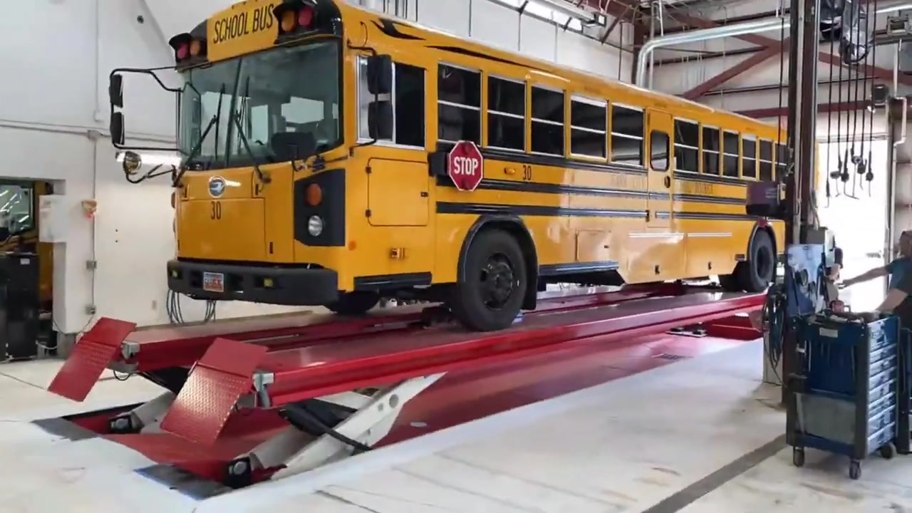 School bus positioned in a vehicle lift service bay