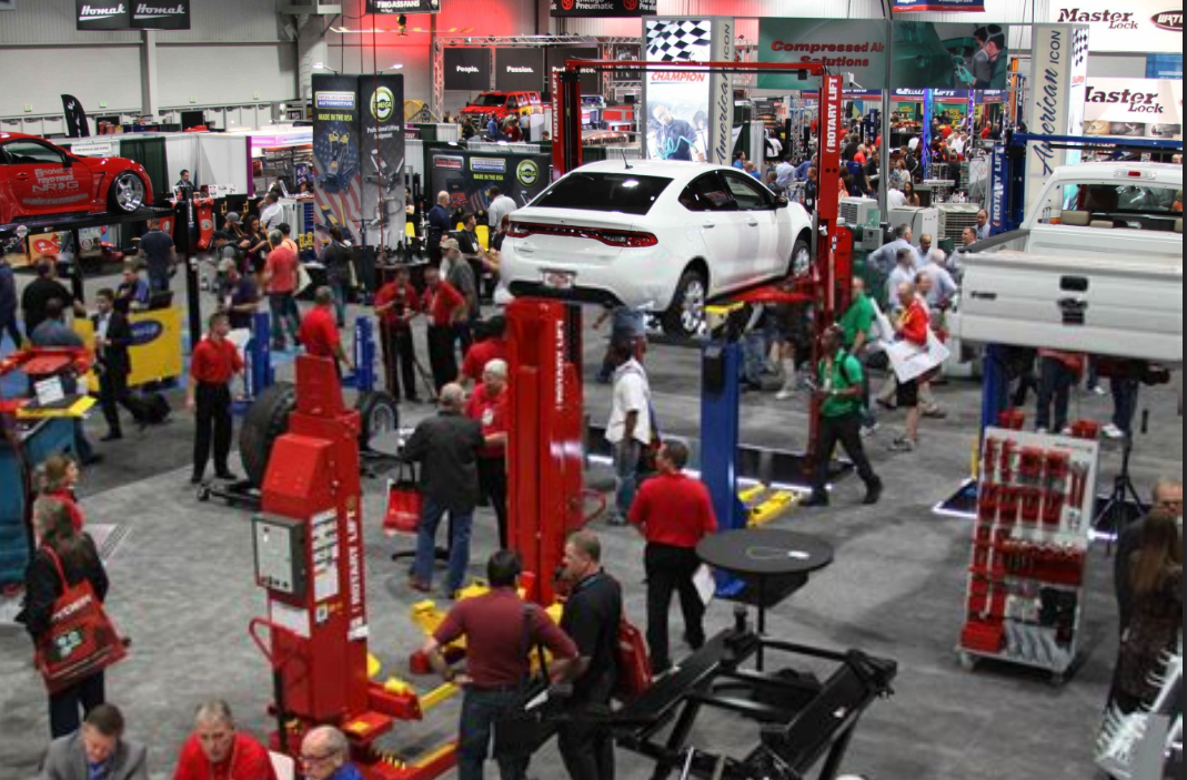Busy SEMA trade show floor with automotive shop equipment